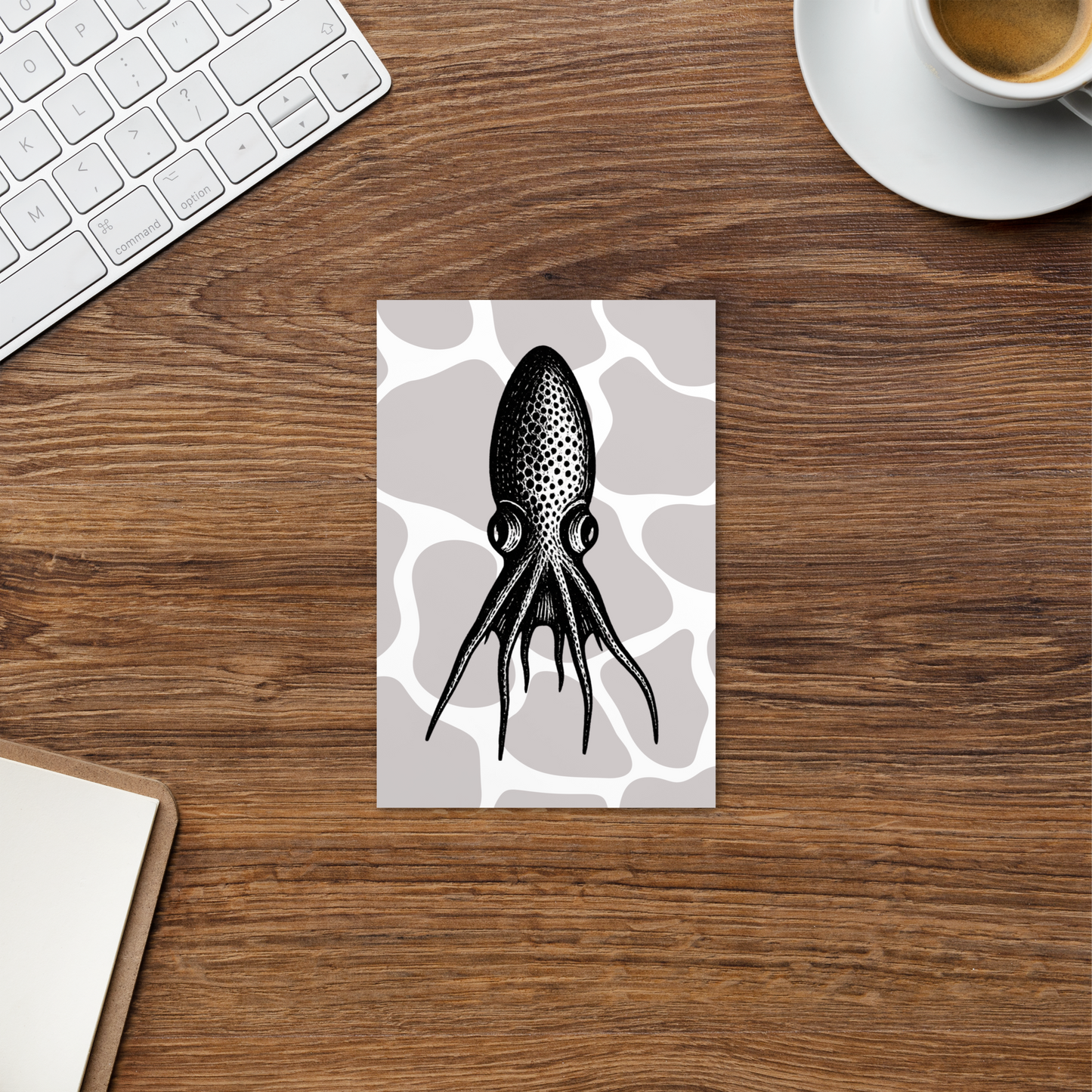 Desk with a card featuring a Blanket Octopus vintage illustration postcard — black and white illustration of Tremoctopus on a patterned background