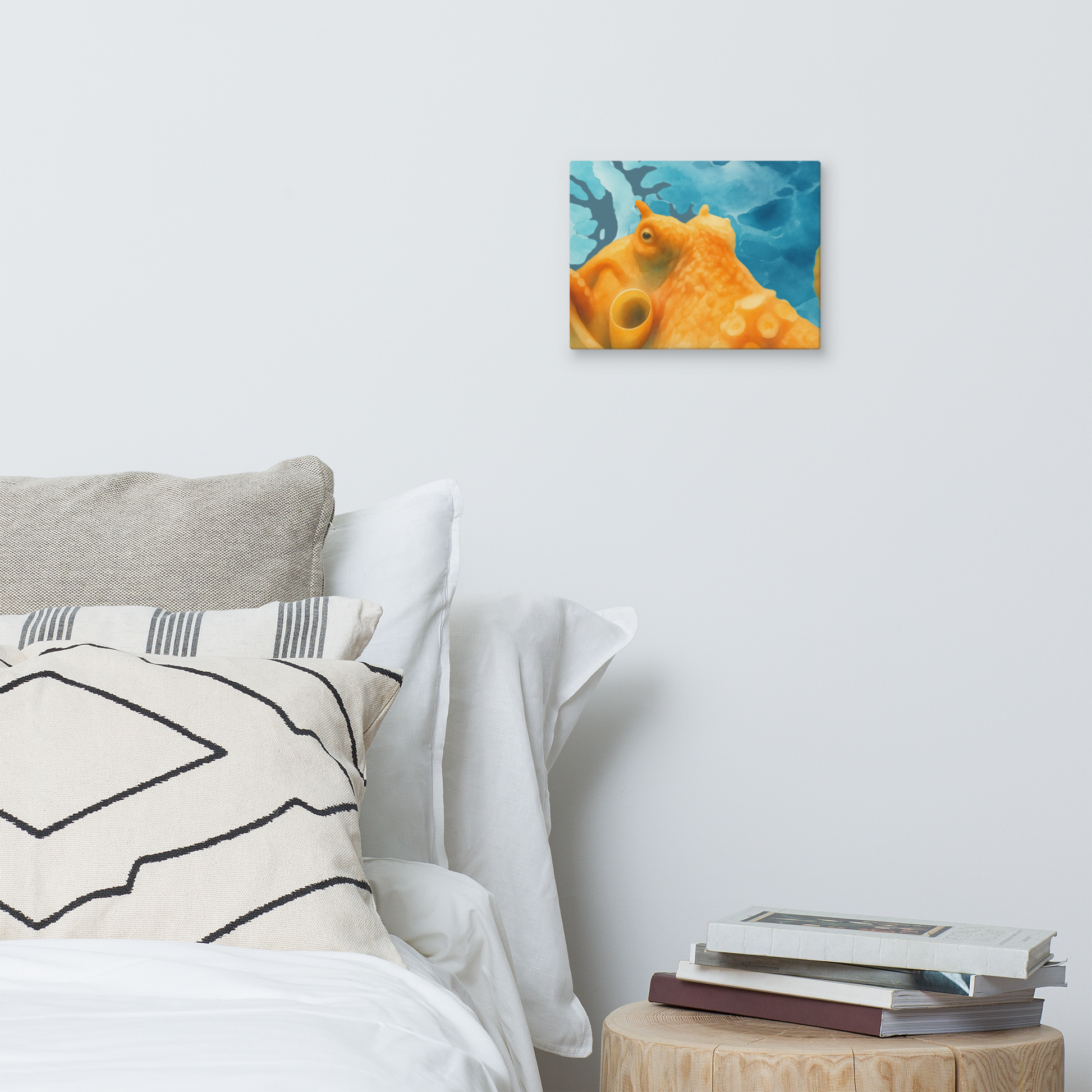 Bedroom with a bed, pillows, and a small table with books, Giant Pacific Octopus watercolor canvas art print 9x12 — orange octopus against blue ocean on premium canvas