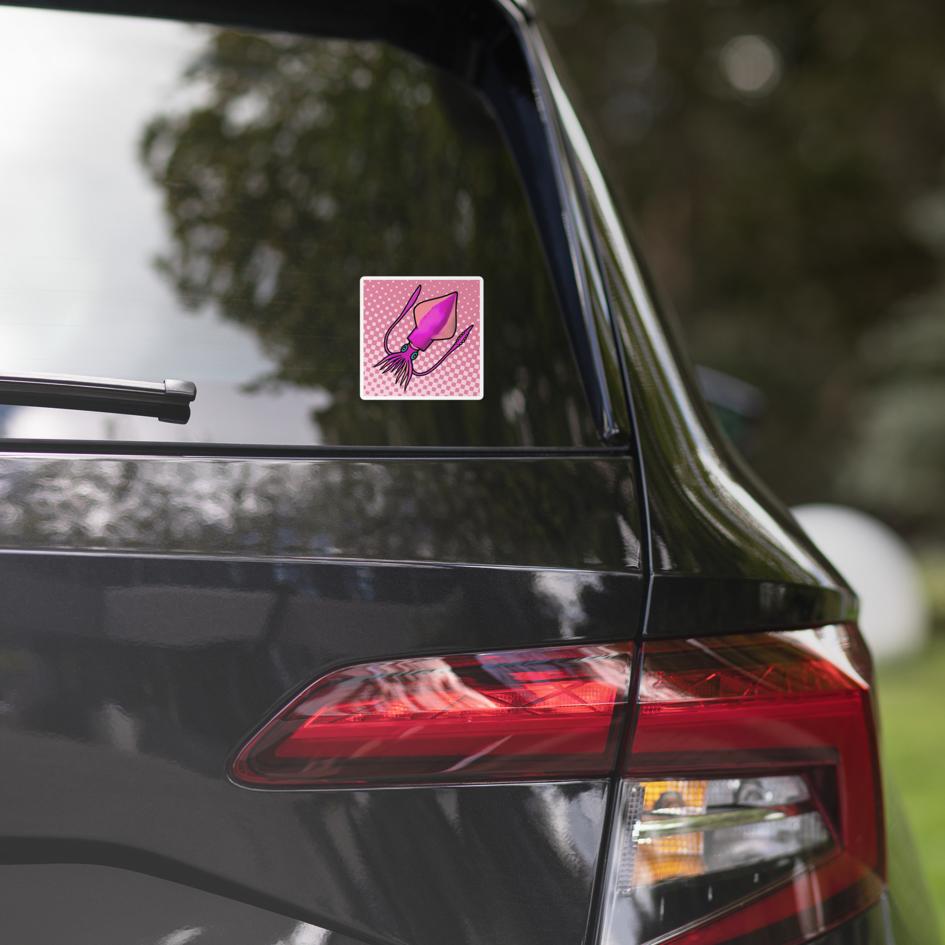 Car with Loligo Vulgaris Squid pop art vinyl sticker 4x4 — pink and magenta squid on checkered pink background on the rear window, blurred greenery in the background