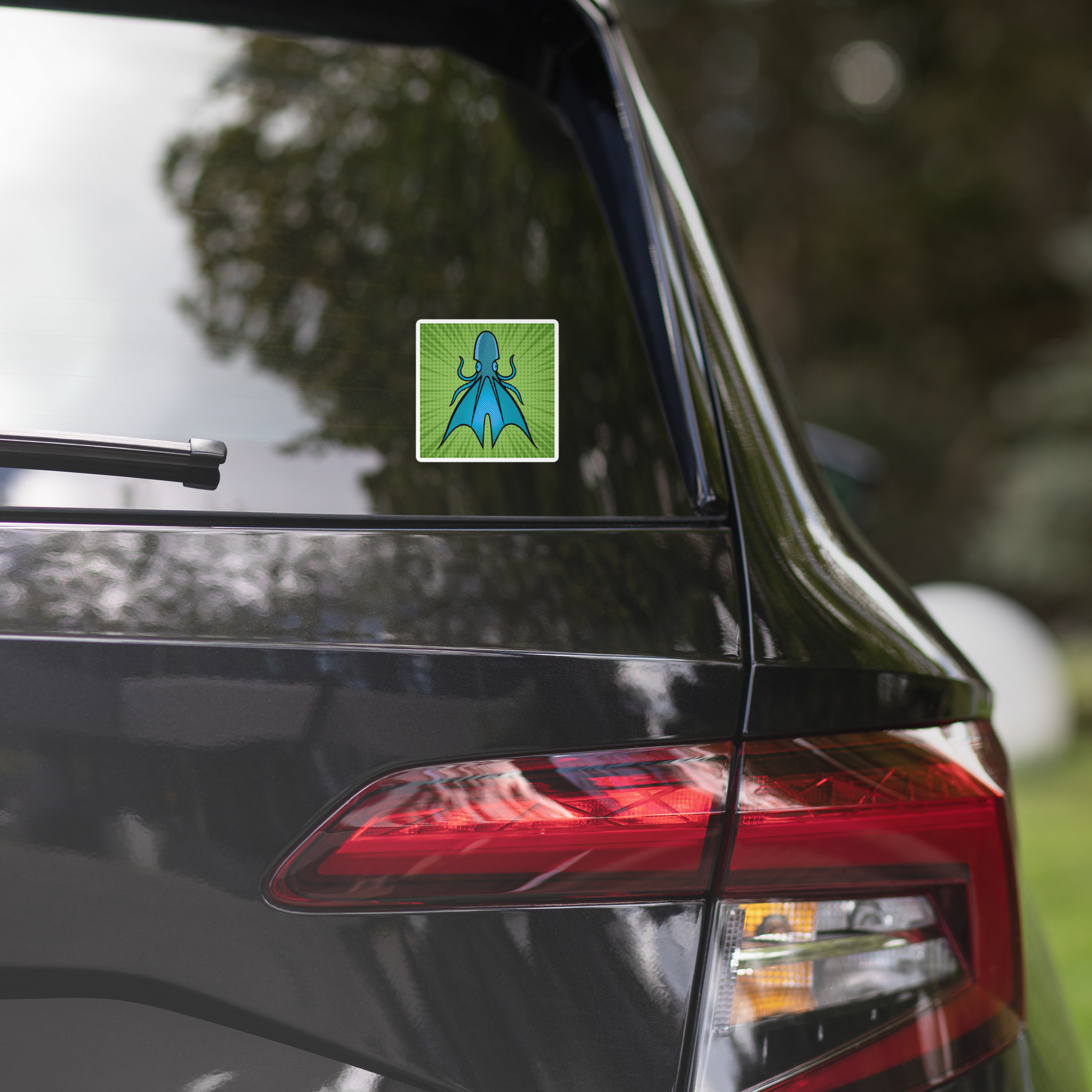 Car with a Common Blanket Octopus pop art vinyl sticker 4x4 — blue and teal octopus with webbing on green sunburst background on the rear window, surrounded by trees.
