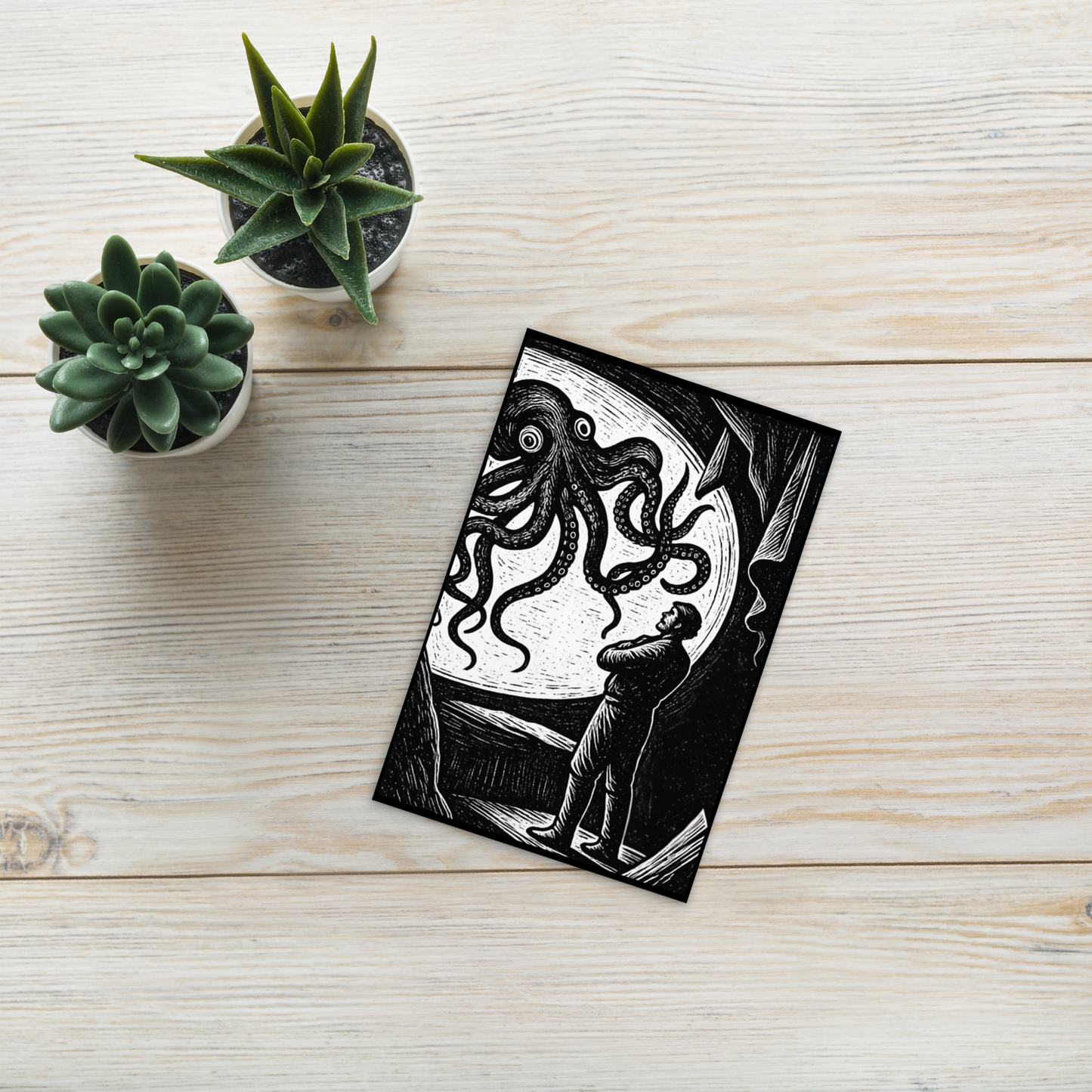 20,000 Leagues Under the Sea lithocut postcard — black and white giant squid scene from Jules Verne illustration on a wooden surface with succulents.